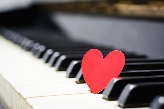 Small red paper heart on piano keys