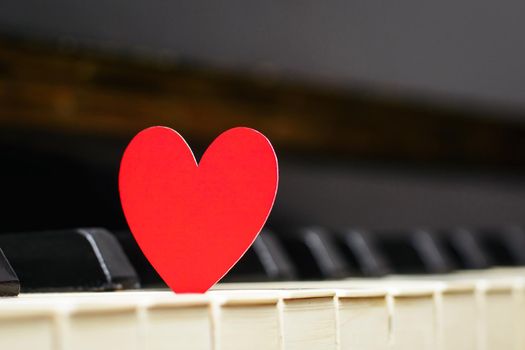 Bright red heart on piano keyboard