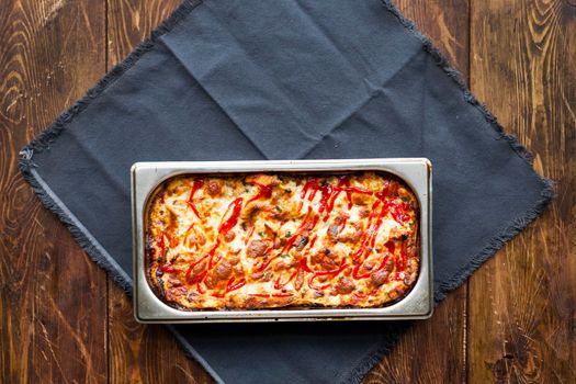 Italian Food. Hot tasty lasagna in ceramic casserole dish on Wooden Table