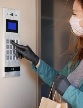 Courier's hands in latex white medical gloves deliver parcels in brown cardboard boxes to the door during the epidemic of coronovirus,COVID-19.Safe delivery of online orders during the epidemic.