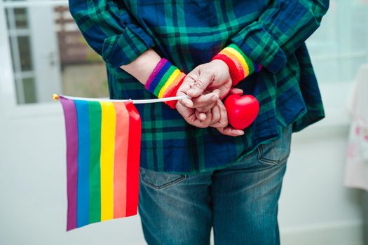 Asian woman with rainbow flag, LGBT symbol rights and gender equality, LGBT Pride Month in June.