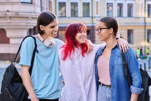 Happy smiling teenage friends hugging outdoor, on city street. Friendship, community, youth, lifestyle, leisure fun concept