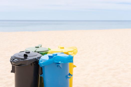 Clean beach garbage bins. Multi colored garbage containers for separate collection of garbage stand on empty beaches near the ocean