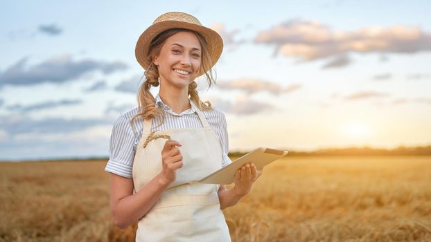 Woman farmer straw hat smart farming standing farmland smiling using digital tablet Female agronomist specialist research monitoring analysis data agribusiness Caucasian worker agricultural field