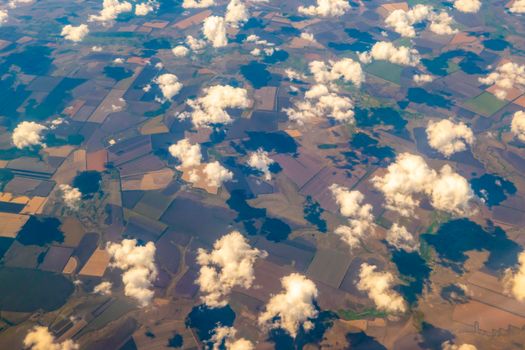 Aerial photo of Farmland . Agricultural Landscape. a pattern of round and rectangular compressed, plowed and green fields, covered with a lace of clouds. View from the plane High quality photo