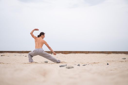 Caucasian man with long hair practicing qigong outdoors