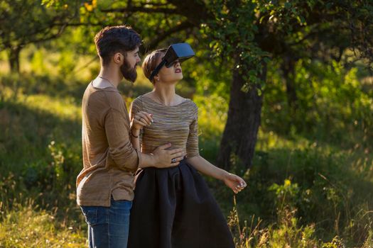 couple in nature, girl in virtual reality glasses close-up