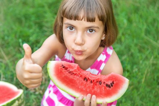 child eats a watermelon in the garden. Selective focus.