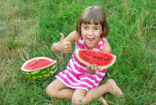 child eats a watermelon in the garden. Selective focus.