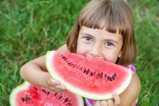 child eats a watermelon in the garden. Selective focus.