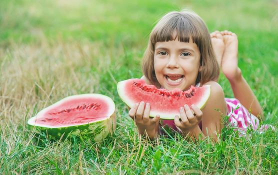 child eats a watermelon in the garden. Selective focus.