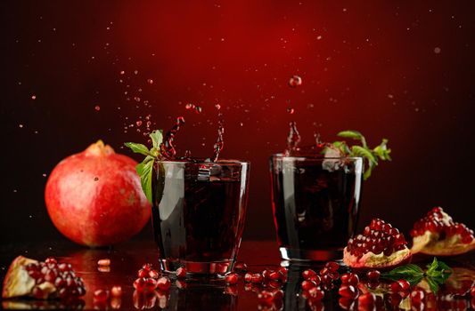 Pomegranate juice with pomegranate seeds, spilled in a glass