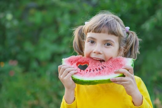 child eats a watermelon in the garden. Selective focus.