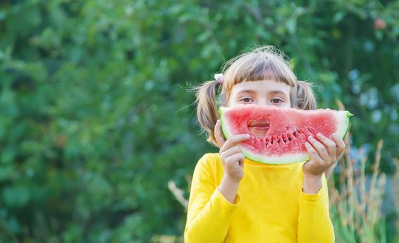 child eats a watermelon in the garden. Selective focus.