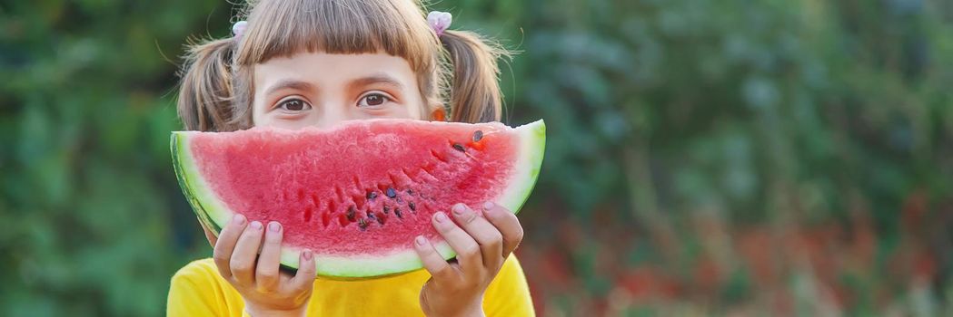 child eats a watermelon in the garden. Selective focus.