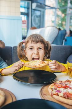 The child eats cheese pizza. Selective focus.