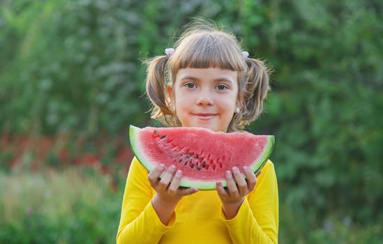 child eats a watermelon in the garden. Selective focus.