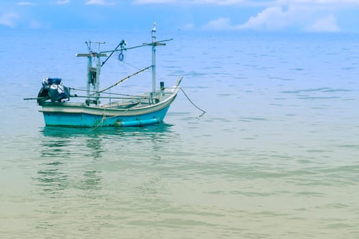 Fishing boat near shore in blue sea and blue sky meet. Thailand holiday summer vacation concept.