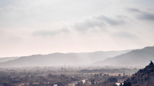 Gray mountains layers in the fog clouds flowing over forest beautiful landscape nature