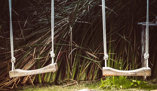 Empty swing on children playground, Children swing in the park, wooden swing, wooden
