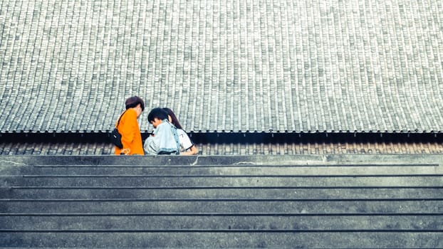 Tourists in front of huge traditional Chinese architecture roof background