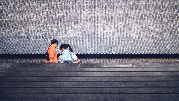 Tourists in front of huge traditional Chinese architecture roof background