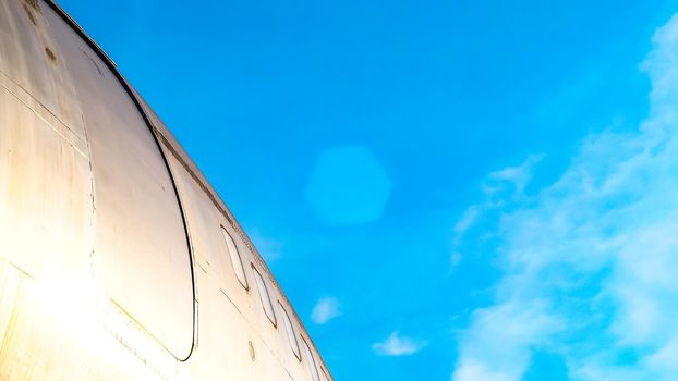 modern airplane parked on airport runway isolated on blue sky background side view of white jet engine passenger