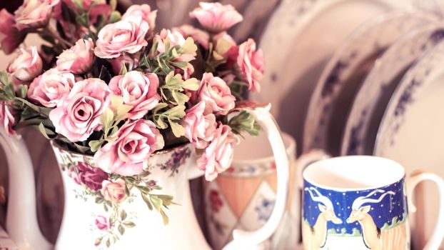 Bouquet vintage group of pink roses in ceramic pot jar on wooden table, soft focus