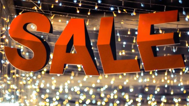 Store sale sign. Special offer banner with the red sale text gold bokeh blur background