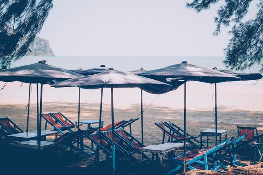 Sun umbrellas on a beach, with a view of a horizon line over the sea, sky, a symbol for holiday vacation. Summer time background