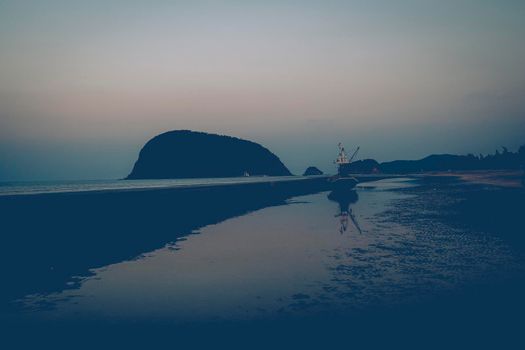 Silhouette people walking on the beach in sunset view.  Beach and mountains overlooking the ocean