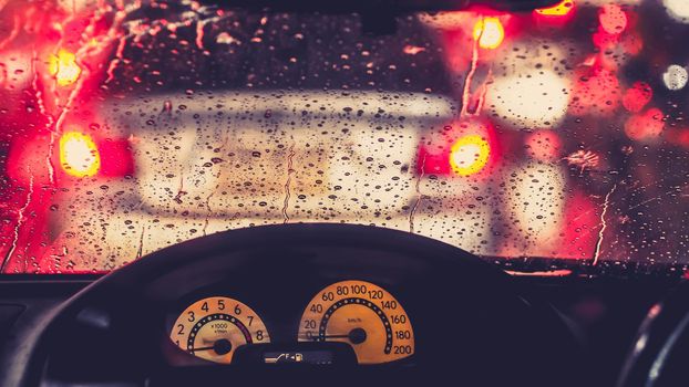 Interior of car when rains. De focused blur of light on the road in a raining day