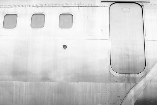 Windows of the white metal surface airplane with emergency exit security escape.
