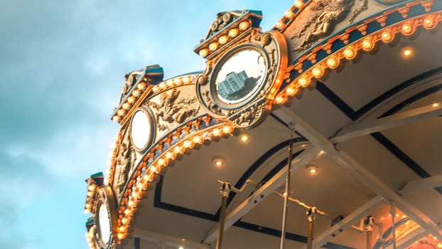 Merry-Go-Round (carousel) illuminated at night.reflection cityscape against evening sky in summer .festival happy time idea