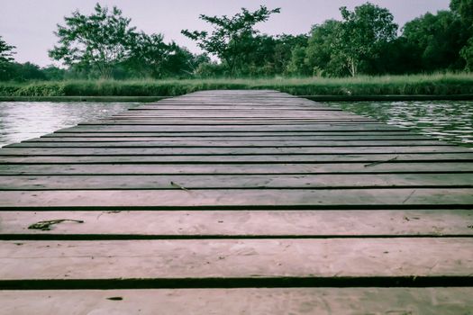 Old Wooden Foot Bridge with handrails over the sea .moving on concept idea