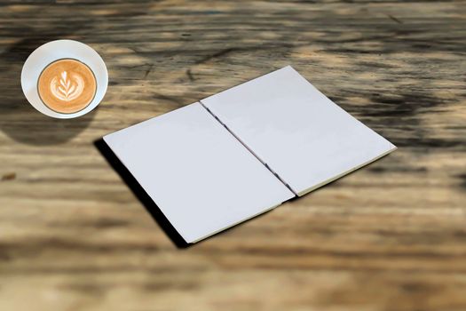 A cup of coffee and white paper notebook  on Wooden table background. outdoor party idea