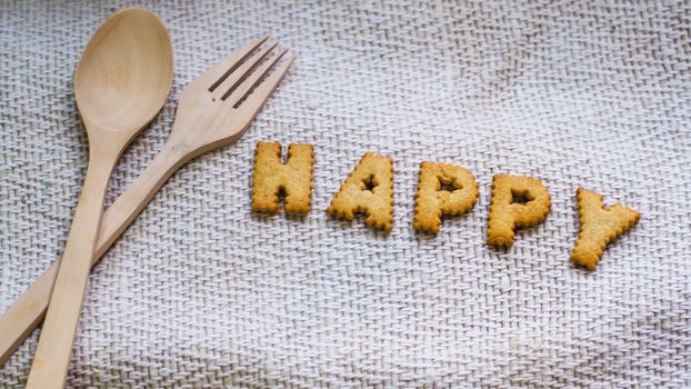 Cookies in the form of the alphabet prospect. Happy from homemade cookies on dark white background. Happy cookies concept