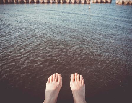 A man foot in the stream line of deep dark water. Touching nature. Nature healing concept idea