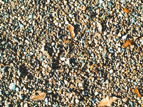 Pebble or stone and rock dried fallen leaves ground on sand beach or river summer holiday background