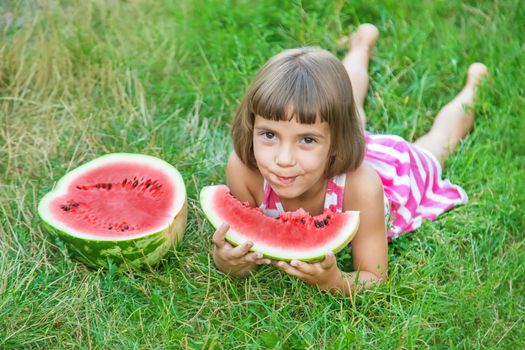 child eats a watermelon in the garden. Selective focus.
