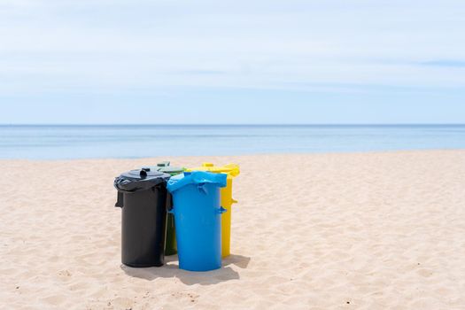 Clean beach garbage bins. Multi colored garbage containers for separate collection of garbage stand on empty beaches near the ocean