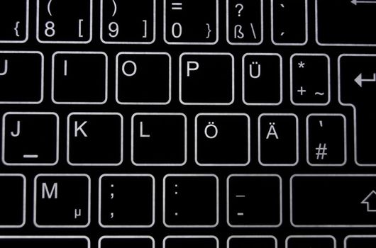 Close-up of a part of a black virtual keyboard with white backlit 'keys' 