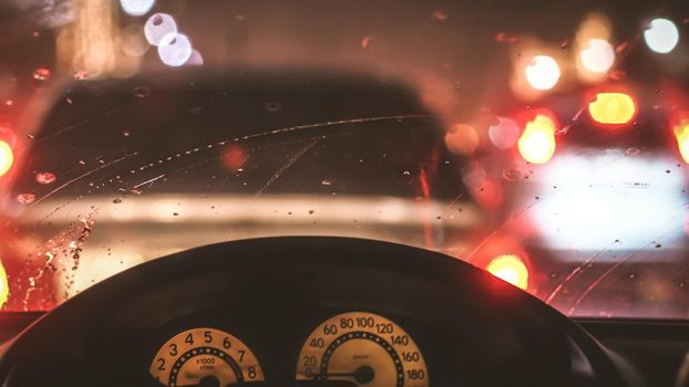 Interior of car when rains. Defocused blur of light on the road in a raining day