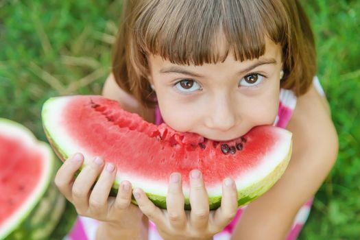 child eats a watermelon in the garden. Selective focus.