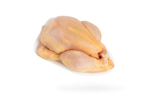 Raw corn chicken isolated on white background. The chicken carcass is packed in a white plastic tray. Yellow meat chicken feed corn.