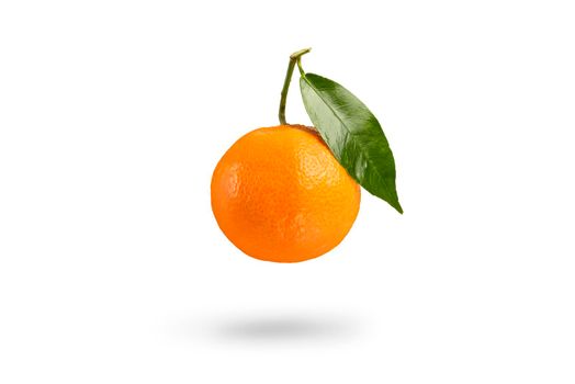 Tangerine with green leaf falls casting a shadow .Fresh tangerine on a white isolated background. Texture of mandarin close up