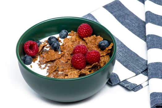 Muesli, isolate on white. Breakfast, healthy food and diet. Muesli with fruits and milk in a plate. Blueberries, strawberries and raspberries on a background of muesli flakes.