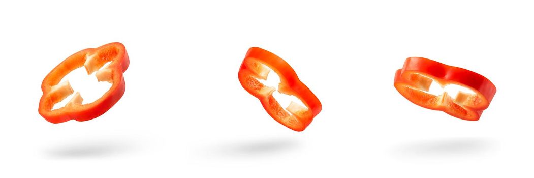 Set of slices of red pepper drops on a white background. Paprika flying in air on isolated white background.