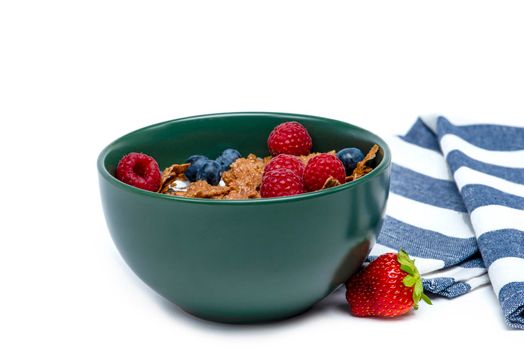 Muesli, isolate on white. Breakfast, healthy food and diet. Muesli with fruits and milk in a plate. Blueberries, strawberries and raspberries on a background of muesli flakes.