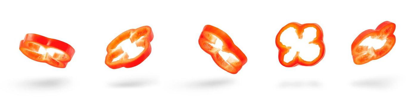 Set of slices of red pepper drops on a white background. Paprika flying in air on isolated white background.